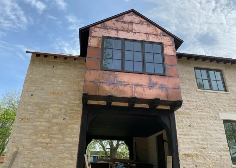 Copper metal panel facade on a stone building for Roof Repair in De Soto
